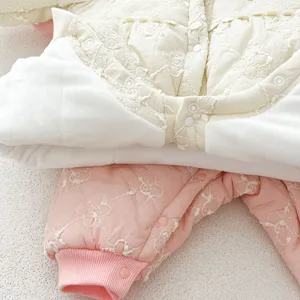 Close-up detail of infant winter quilted fleece-lined romper with floral embroidery buttons