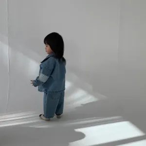 Detailed view of kids denim jacket and pants set, stylish and comfortable outfit for toddlers.