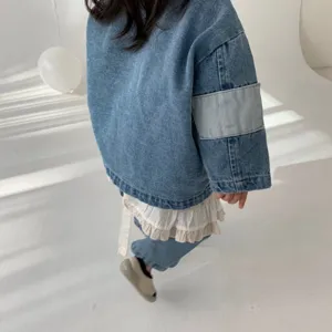 Detail shot of kids denim jacket and jeans set, showcasing soft fabric and cute ruffle hem.