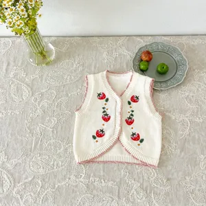 Detailed view of baby knitted cardigan vest featuring cute strawberry embroidery.