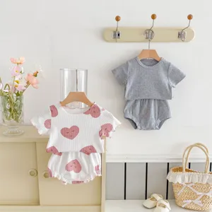 Vue détaillée de l'ensemble haut côtelé et bloomers pour bébé dans un style pastel.
