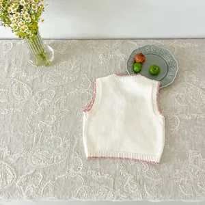 Detailed view of the baby knitted vest back, showing soft texture and pink ribbed trim.