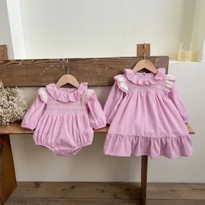 Dettaglio set tutina vestito neonata rosa manica lunga, colletto pizzo petto smock accogliente.