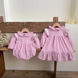 Vista dettagliata del set tutina e abito a manica lunga rosa per neonata con volant.