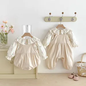 Vista di dettaglio camicetta floreale bambina e salopette beige, set casual carino per neonati.
