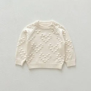 Infant knit sweater with cute heart popcorn pattern, cozy beige baby pullover for autumn.
