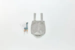 Détail de barboteuse en tricot pour bébé, body gris doux en coton, style minimaliste.