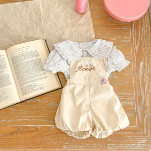 Dettaglio camicetta floreale neonata e pantaloncini beige, set carino bimba due pezzi