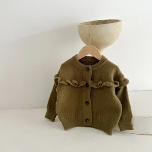 Primo piano dettaglio del cardigan in maglia per neonato verde oliva con volant e bottoni.