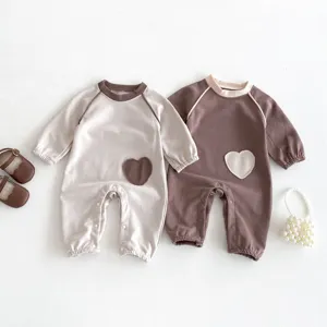 Detailansicht süßer Baby Langarm Strampler mit Kontrast Herz Patch, weicher Stoff.