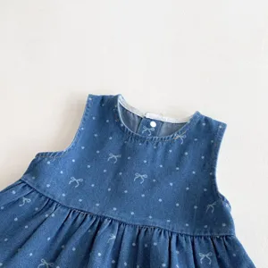 Detailansicht eines süßen Baby Mädchen Jeans Kleids mit niedlichen Schleifen und Mustern.
