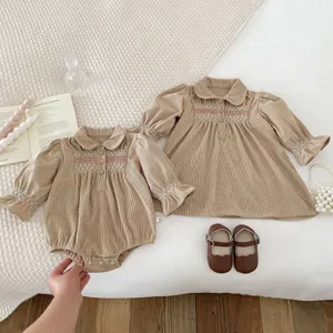 Cute corduroy baby girl romper and dress set with elegant smocked embroidery details.