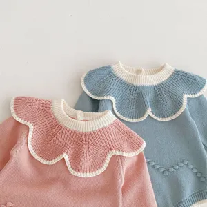 Baby Strick-Strampler Detail mit grossem Rüschenkragen und feinem Bommel-Design.