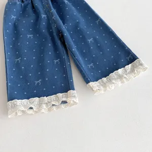 Nahaufnahme süßer Kleinkind Mädchen Jeanshosen mit weißen Punkten und filigranen Spitzenvolants.