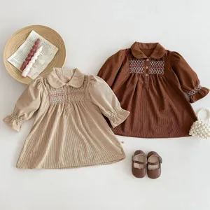 Corduroy toddler girls dress detail view, featuring delicate smocked embroidery and cute collar.
