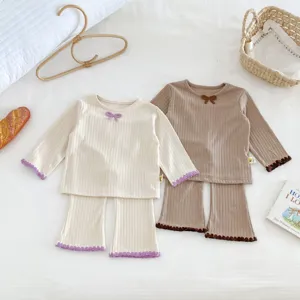 Detail shot of cozy ribbed cotton baby thermal sets with cute bows and lettuce trim hems.