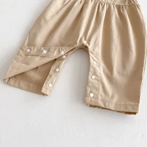 Infant baby romper snap button crotch detail close up in solid khaki color cotton fabric.