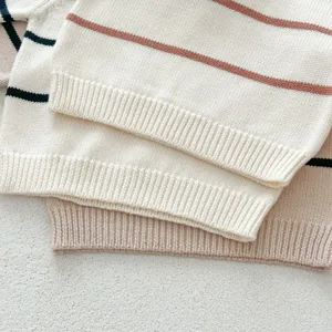 Infant striped knit sweater detail, soft baby pullover top texture close-up shot.
