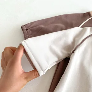 Detailansicht der Babylangarm-Body-Ärmeltextur und der feinen Nahtverarbeitung für Qualität.
