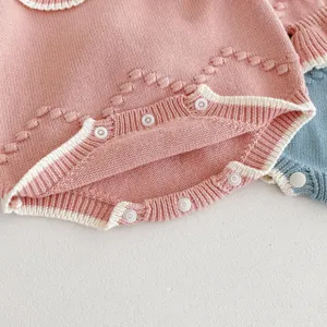 Nahaufnahme Detail des Baby Strick Overalls, weicher rosa Wollstoff mit Druckknöpfen.