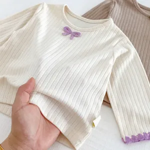 Cute baby ribbed long-sleeve top with bow detail, soft knit fabric for infant autumn wear.
