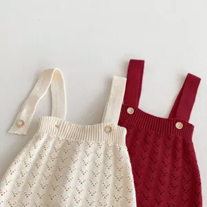 Detailansicht von Baby Strick-Träger-Rompern mit feinem Lochmuster und süßen Knöpfen.