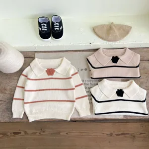Infant knit sweater detail showcasing lapel collar, striped design and cozy autumn fabric.