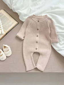 Nahaufnahme des Baby Strickoveralls mit weicher Rippstruktur und Holzknopfverschluss.