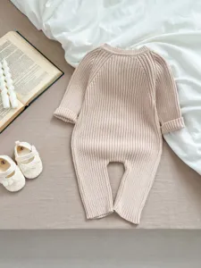 Nahaufnahme des Baby Strick Overalls in sanftem Beige mit feiner Rippenstruktur und Stil.