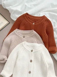Detailansicht der Baby Strickjacke, weiche Rippstruktur, lange Ärmel mit Holzknöpfen.