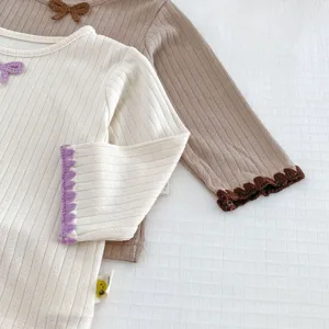 Cute baby long sleeve ribbed top, soft fabric with sweet bow and scalloped cuffs design.