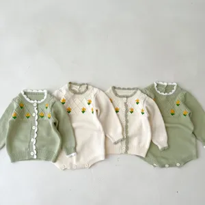Detailed shot of baby girl knit cardigan romper with cute yellow flower embroidery and cozy long sleeves.