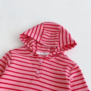Primer plano de los detalles de la sudadera de canalé a rayas rosas con botones y cuello.