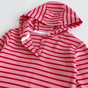 Detalle de sudadera con capucha bebé niña a rayas rosa y roja, top infantil bonito.
