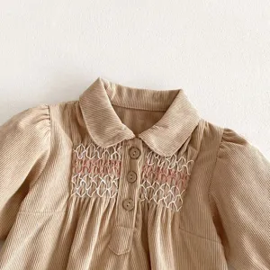 Infant baby girl corduroy dress detail, cute collar, smocking embroidery and wood buttons.