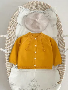 Baby yellow knitted cardigan with cute button design, soft cotton toddler sweater for autumn.