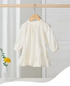 Detailed view of white toddler girl dress featuring delicate butterfly embroidery and elegant tiered skirt.