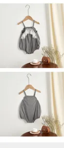 Close-up detail of gray baby romper with cute white lace ruffle trim and thin straps.