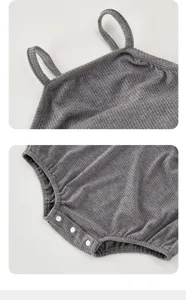 Grey ribbed baby romper detail showing delicate shoulder straps and bottom snap buttons.
