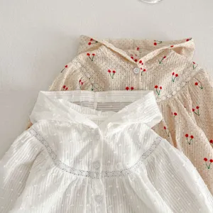 Gedetailleerd overzicht van lichtgewicht zomer babyvest met kersenprint en fijn kanten accent.