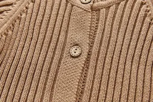 Detaillierte Ansicht des Baby Strick Cardigans mit feiner Rippenstruktur und Holzknöpfen.