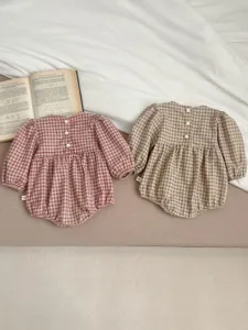 Detailed shot of infant baby girl cotton plaid rompers, cute button-back design, soft fabric.