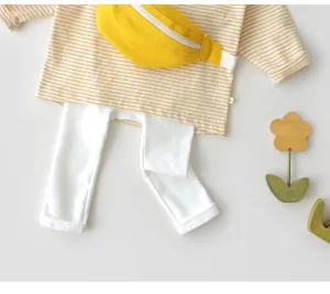 Dettaglio di top a righe in cotone per neonati e leggings bianchi con borsa carina.