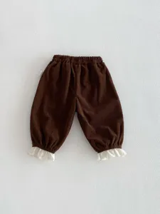 Detailed view of the brown corduroy toddler pants with cute white lace trim cuffs.