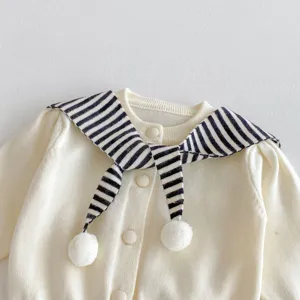 Detailed view of baby knit cardigan collar, striped sailor design with pom pom ties.