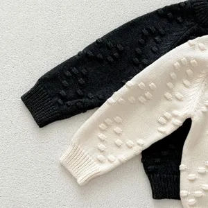 Textured baby knit sweater detail, soft wool cardigan fabric close up, warm infant clothing.