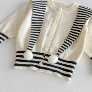 Cozy baby knit cardigan with chic striped collar and cute pom-poms for winter style.