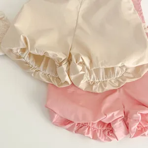 Dettaglio pantaloncini neonata in cotone, copripannolino con volant morbido per bambine dolci.