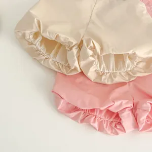 Primo piano dettagliato di adorabili pantaloncini da neonato con volant elastici.