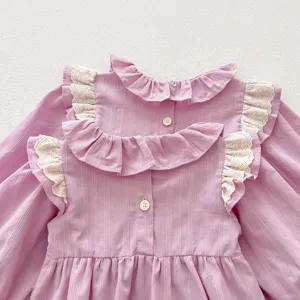 Delizioso abito a maniche lunghe per bambina rosa con volant in pizzo e bottoni sul retro.